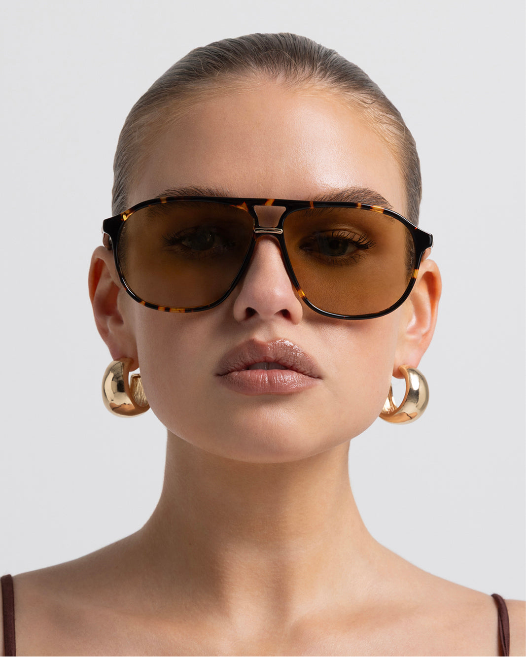 Oversized women's aviator sunglasses with a, flat-top brow bar, keyhole cut, double bridge, and slim arms.