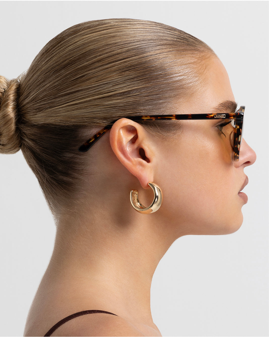 Women's aviator sunglasses in amber tort colourway featuring an oversized modified aviator silhouette with flat-top brow bar, double bridge, angular navigator-inspired shaping, and slim arms for a bold, contemporary look with full coverage.